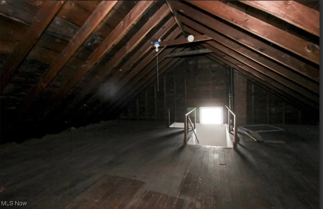 Unfinished attic featuring an upstairs landing