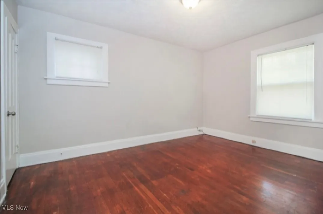 Unfurnished room with baseboards and wood finished floors