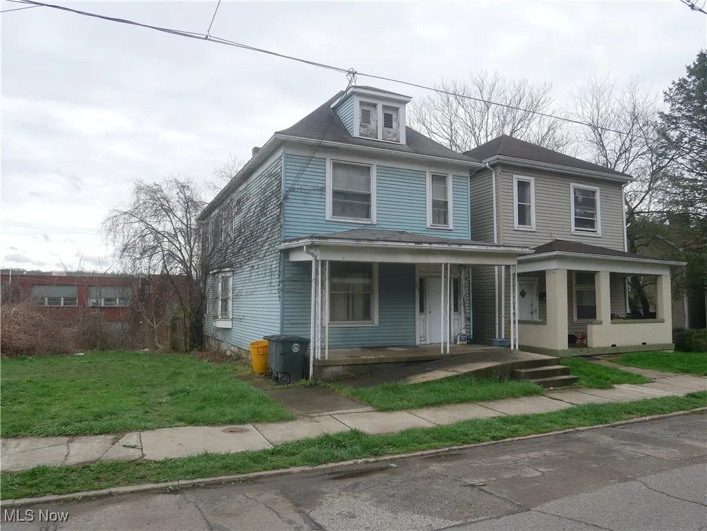 Traditional style home with covered porch and a front yard