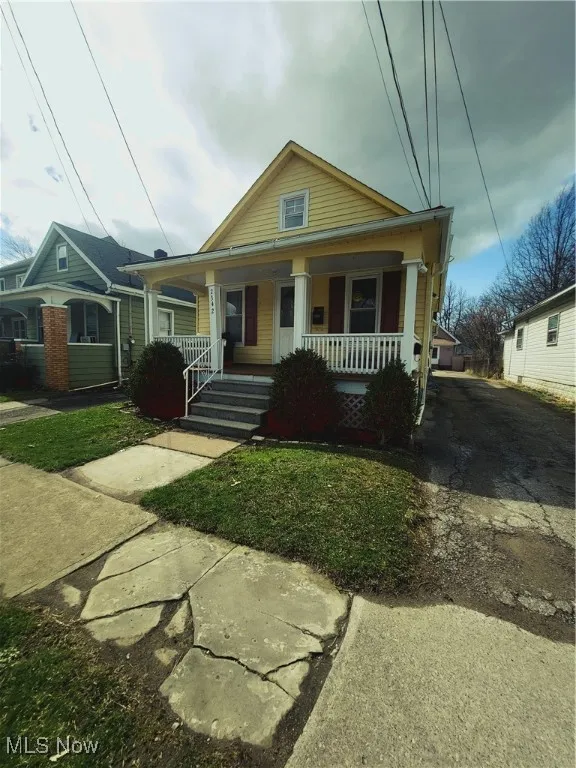 View of front of property featuring aphalt driveway and a porch