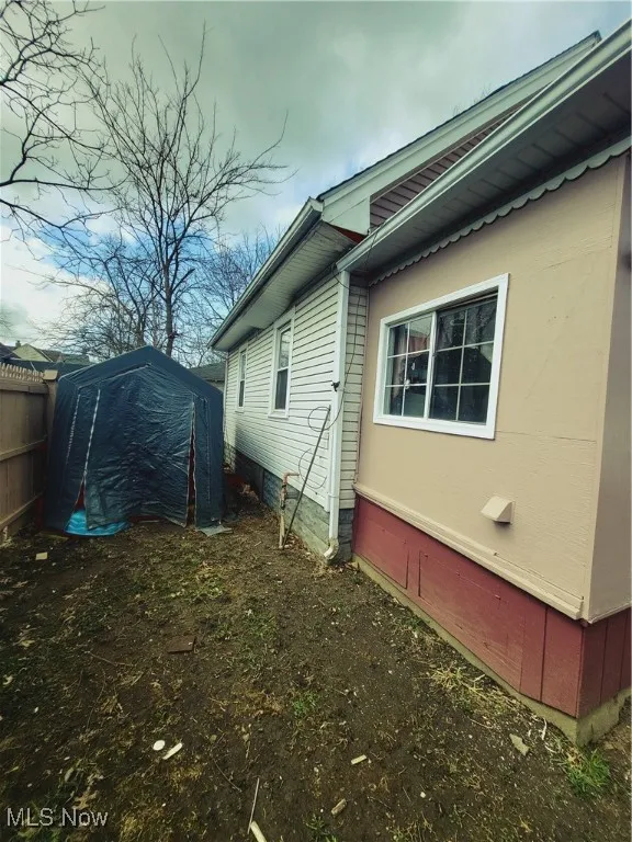 View of property exterior featuring fence