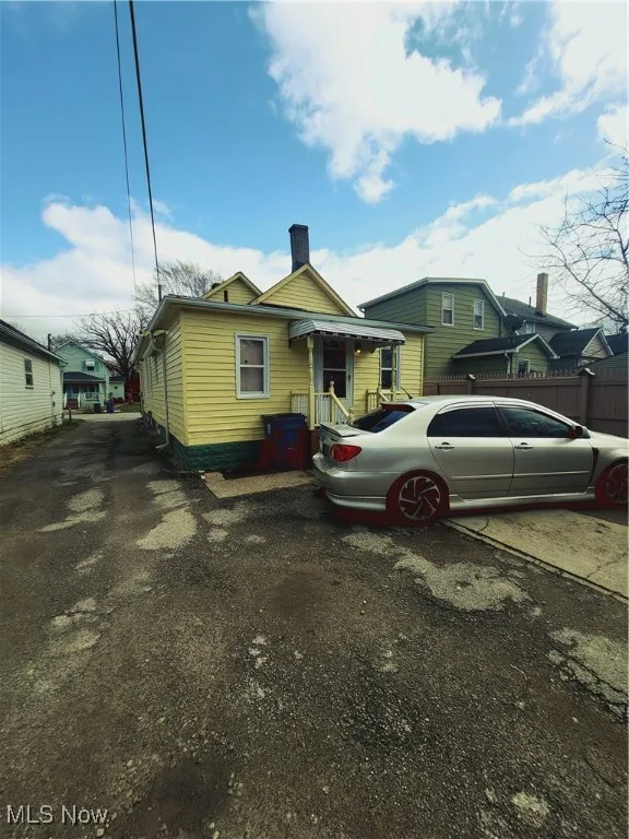 View of front of house featuring fence and a chimney