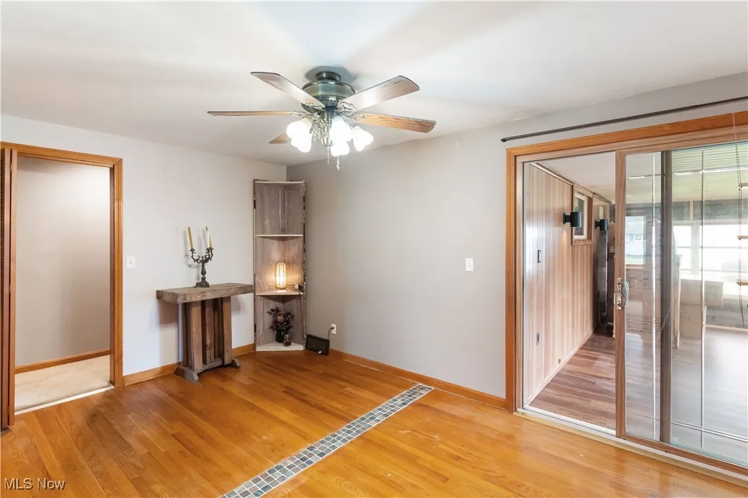 Empty room featuring light wood-style flooring, baseboards, and ceiling fan