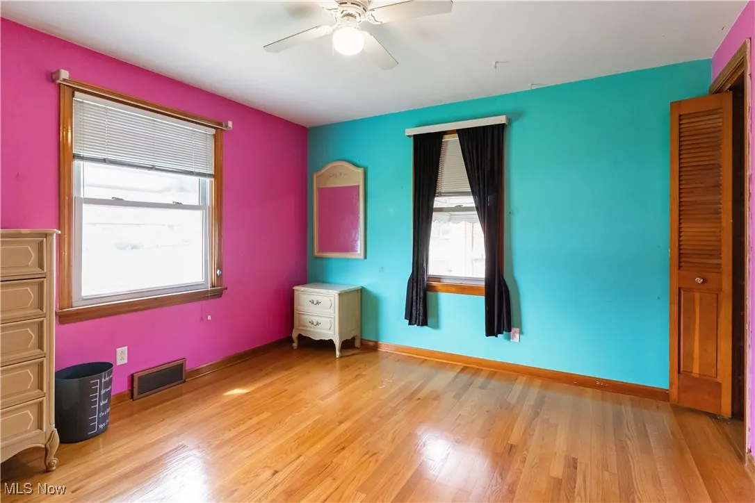 Unfurnished bedroom featuring baseboards, light wood-style floors, ceiling fan, and visible vents