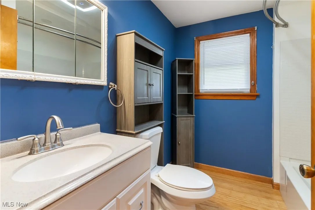 Full bathroom with baseboards, toilet, wood finished floors, vanity, and shower / tub​​‌​​​​‌​​‌‌​‌‌​​​‌‌​‌​‌​‌​​​‌​​ combination
