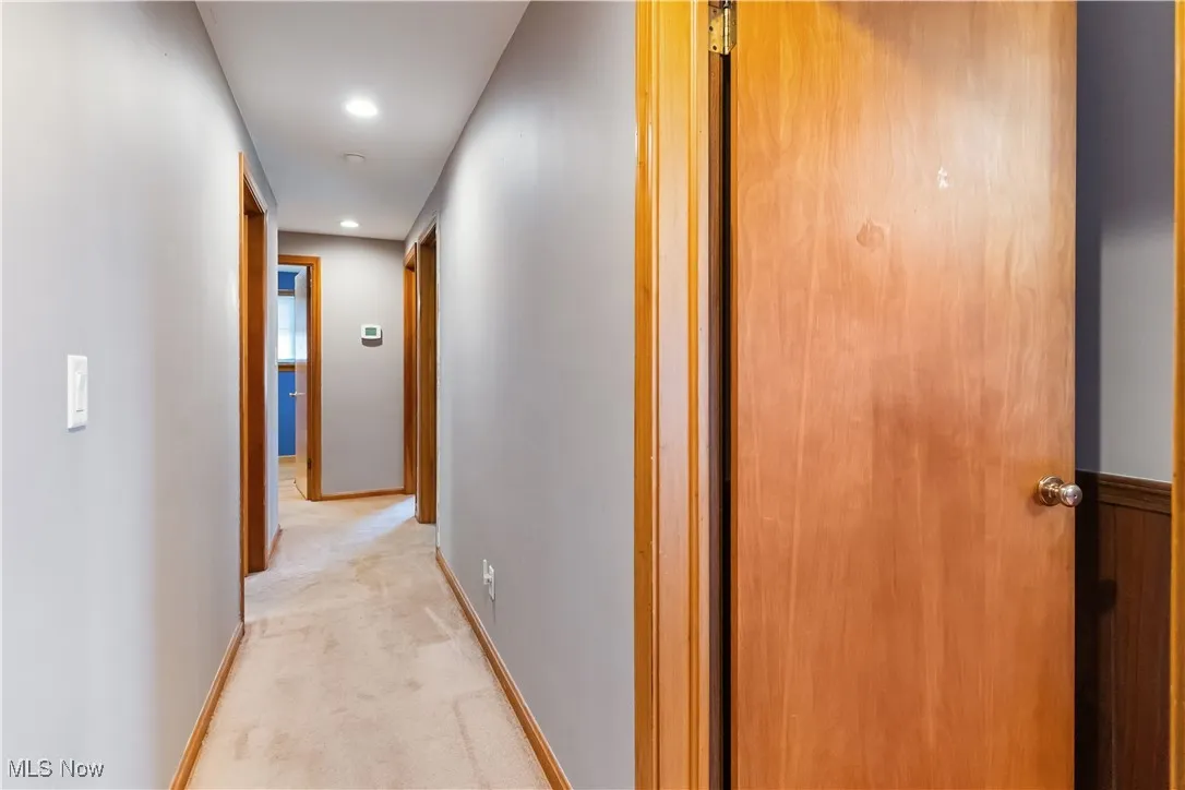 Hall featuring light carpet, baseboards, and recessed lighting