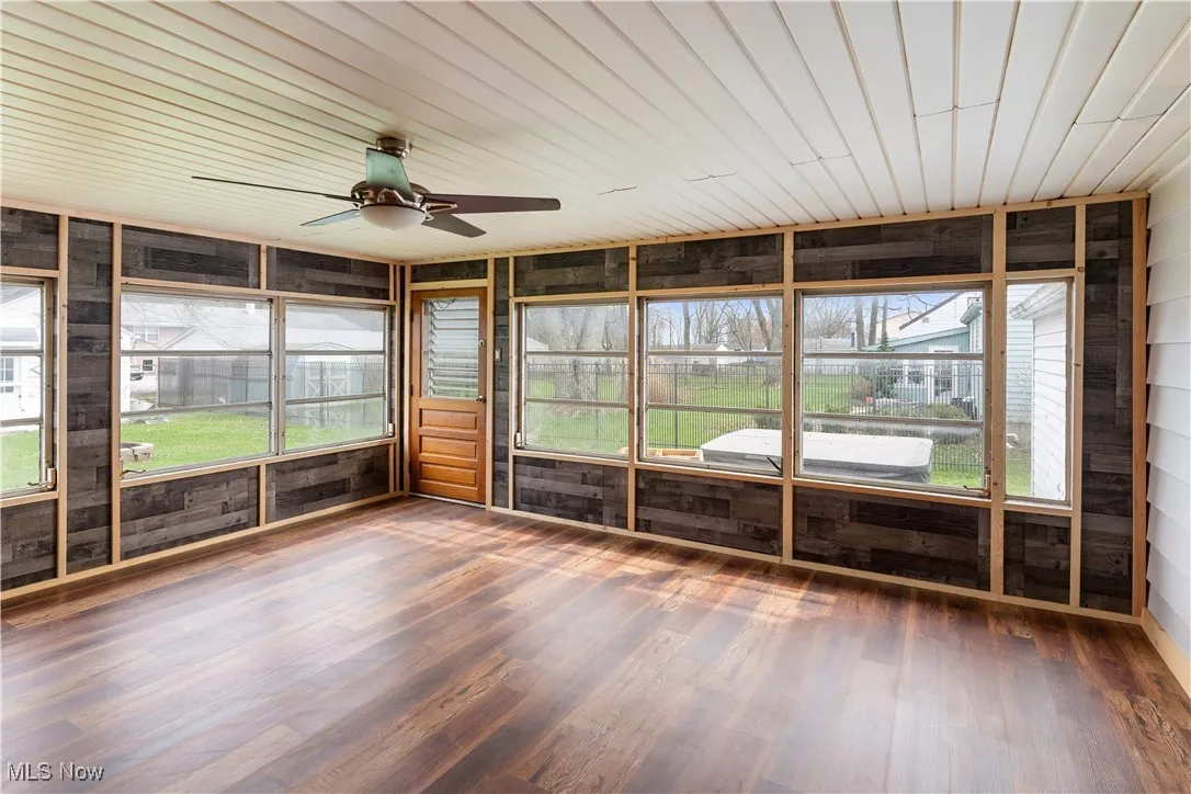 Unfurnished sunroom featuring ceiling fan