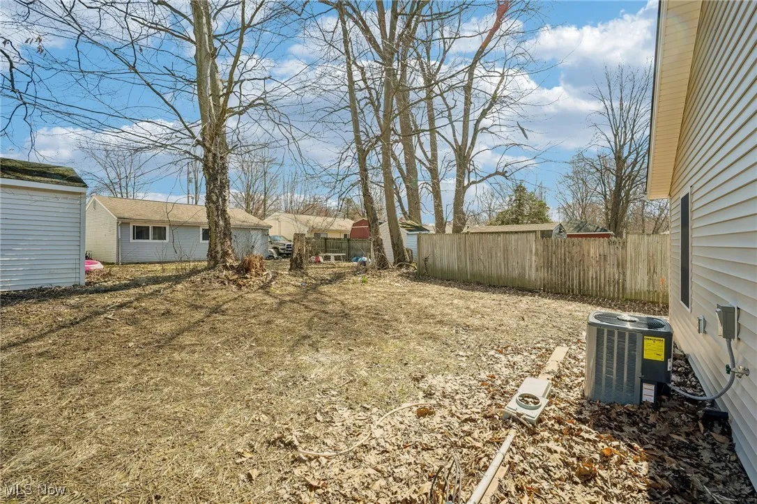 View of yard featuring cooling unit and fence