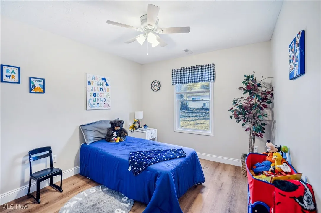 Bedroom with visible vents, baseboards, and wood finished floors