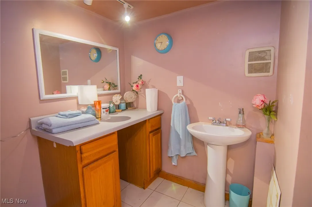 Bathroom featuring tile patterned flooring and a sink