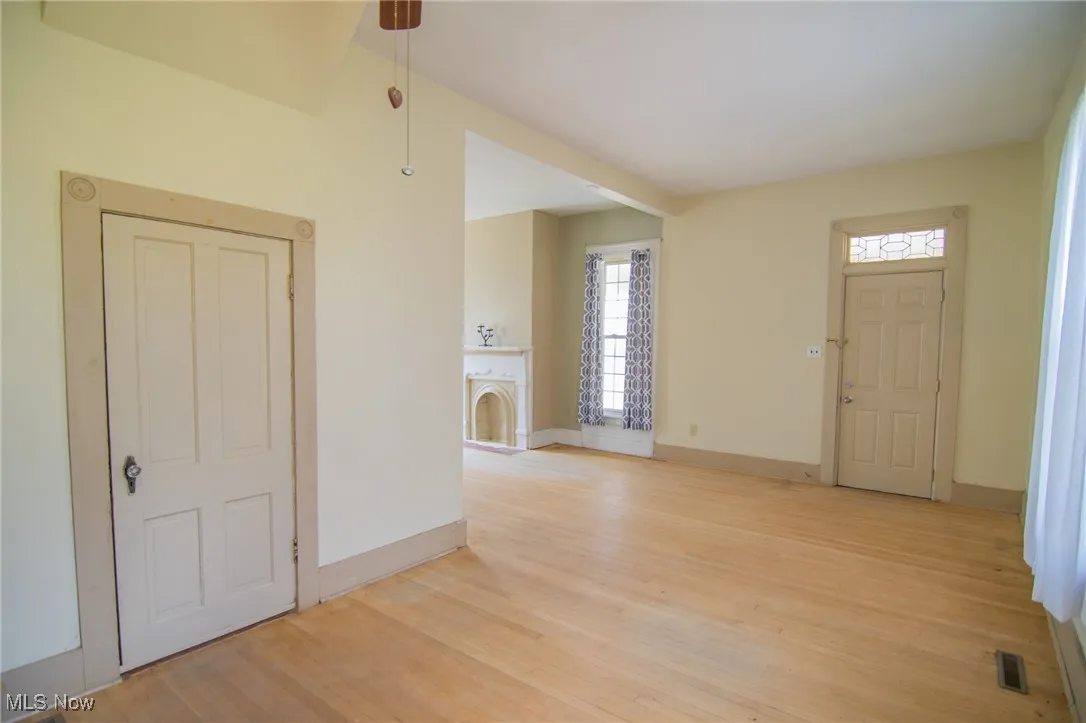 Foyer featuring visible vents, baseboards, light wood finished floors, and a fireplace