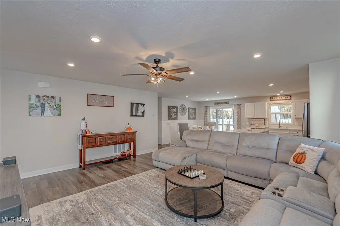 Living area with baseboards, ceiling fan, a textured ceiling, recessed lighting, and wood finished floors