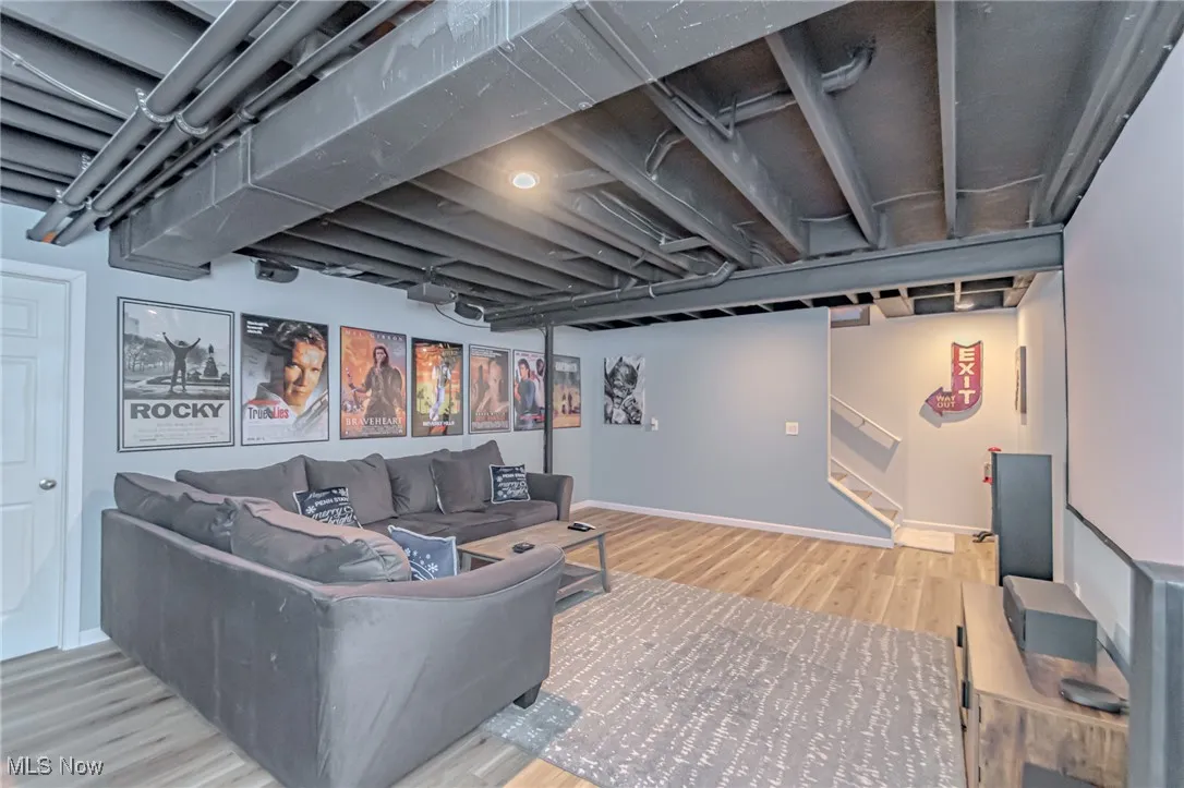 Living room with stairway, baseboards, and wood finished floors