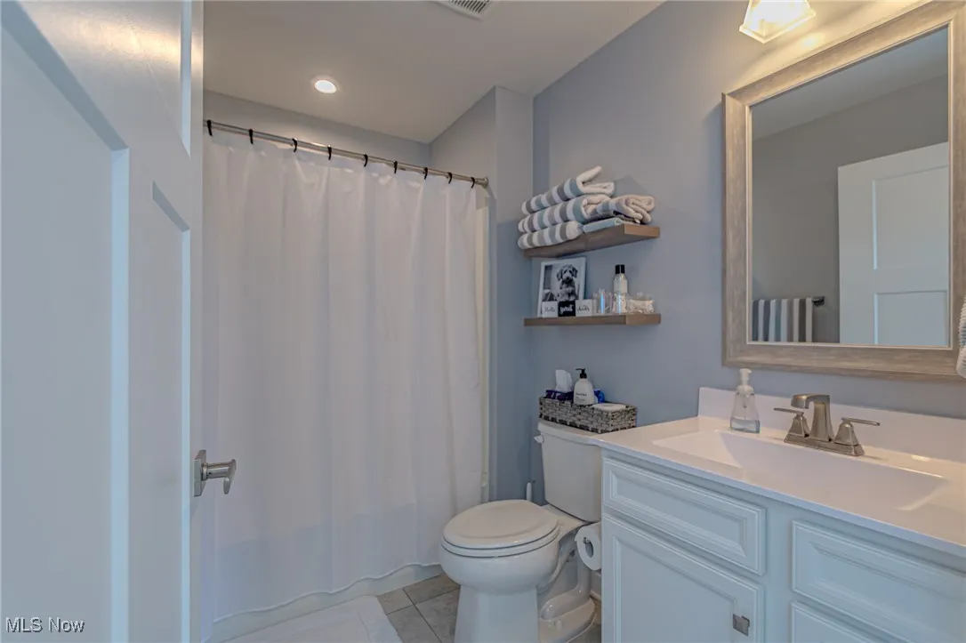 Bathroom with toilet, tile patterned floors, recessed lighting, and vanity