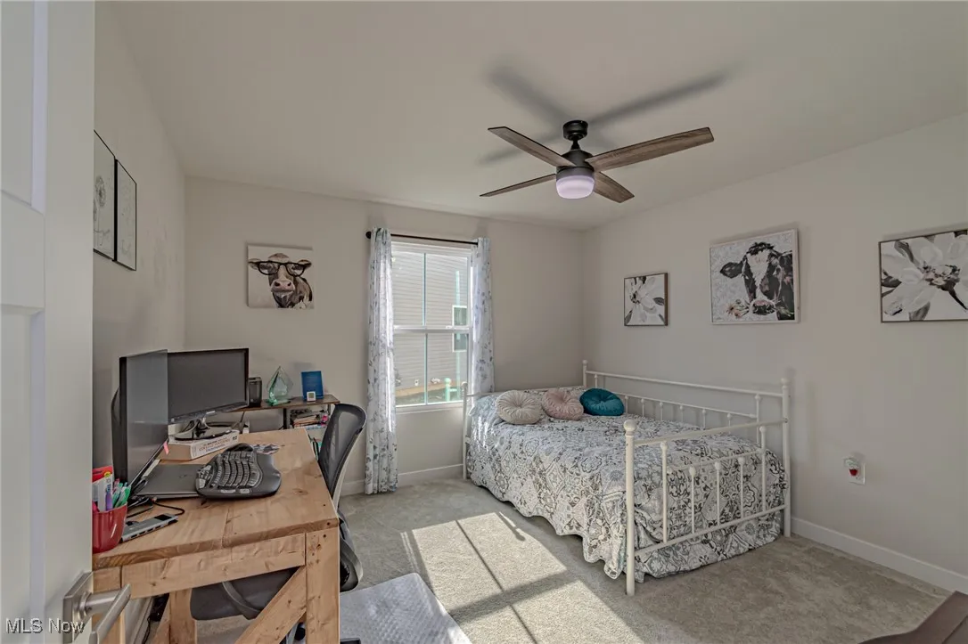 Carpeted bedroom with baseboards and a ceiling fan