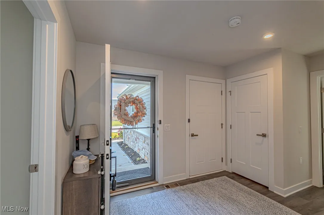 Foyer featuring dark wood-type flooring and baseboards