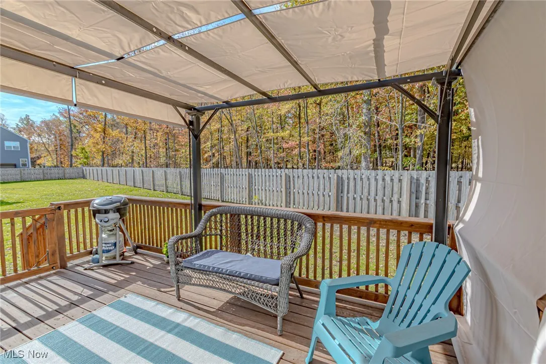 Wooden deck with a fenced backyard and a lawn