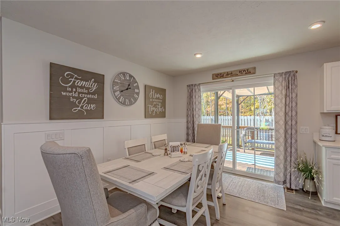 Dining area featuring wood finished floors, wainscoting, and recessed lighting