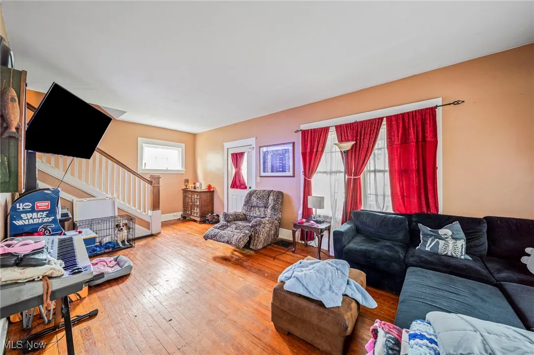 Living room with stairs, baseboards, and hardwood / wood-style floors