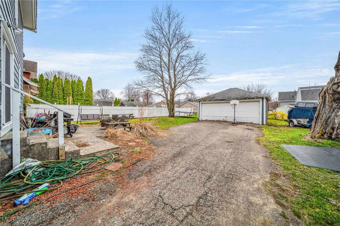 View of yard with an outbuilding, a detached garage, and fence