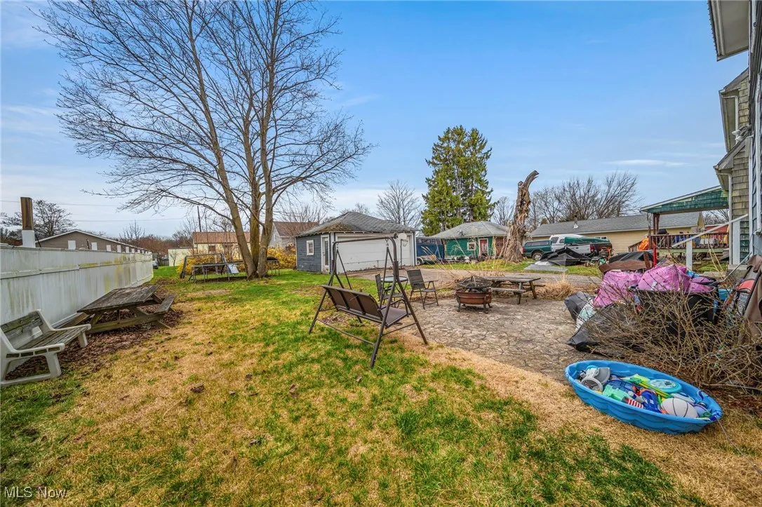 View of yard featuring a fire pit, an outdoor structure, and fence