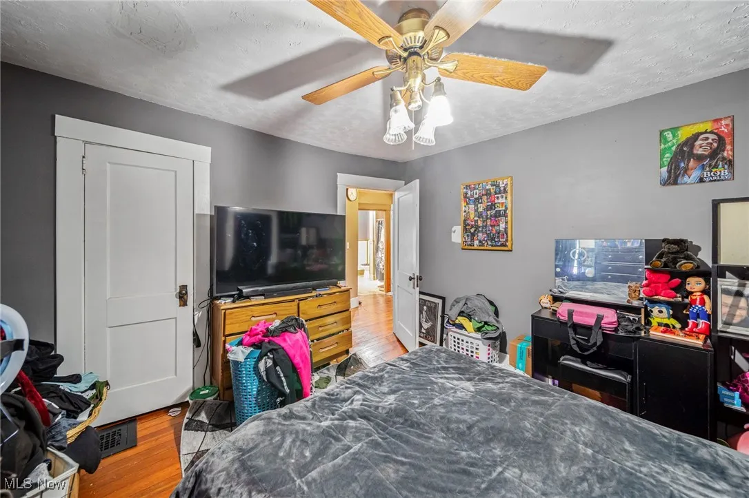 Bedroom featuring visible vents, ceiling fan, wood finished floors, and a textured ceiling