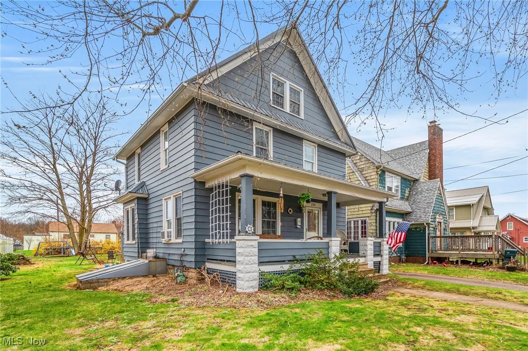 American foursquare style home with a front yard, a porch, and a chimney