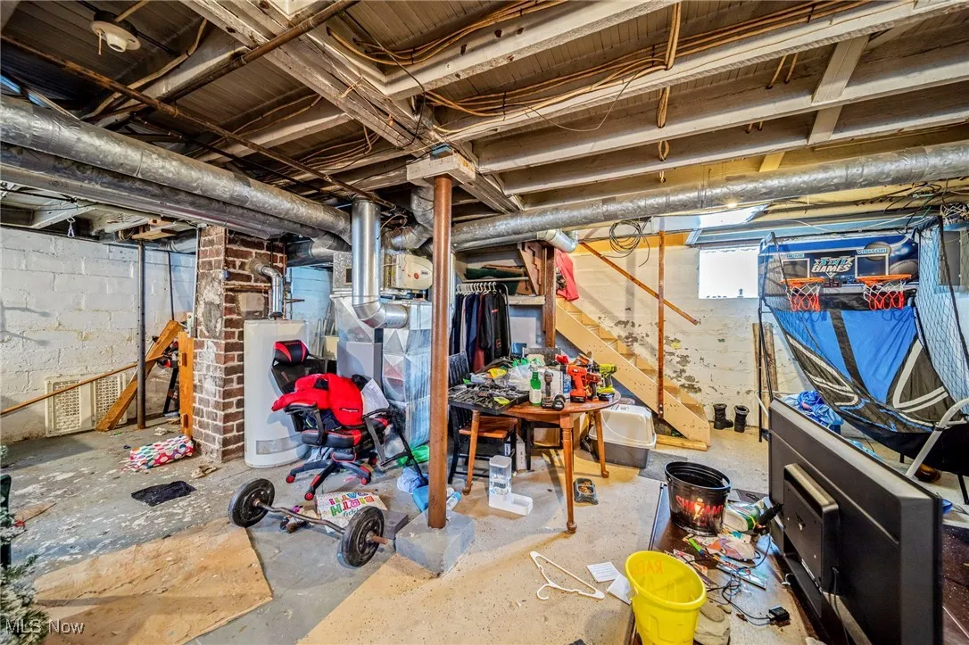 Unfinished below grade area with stairway and water heater
