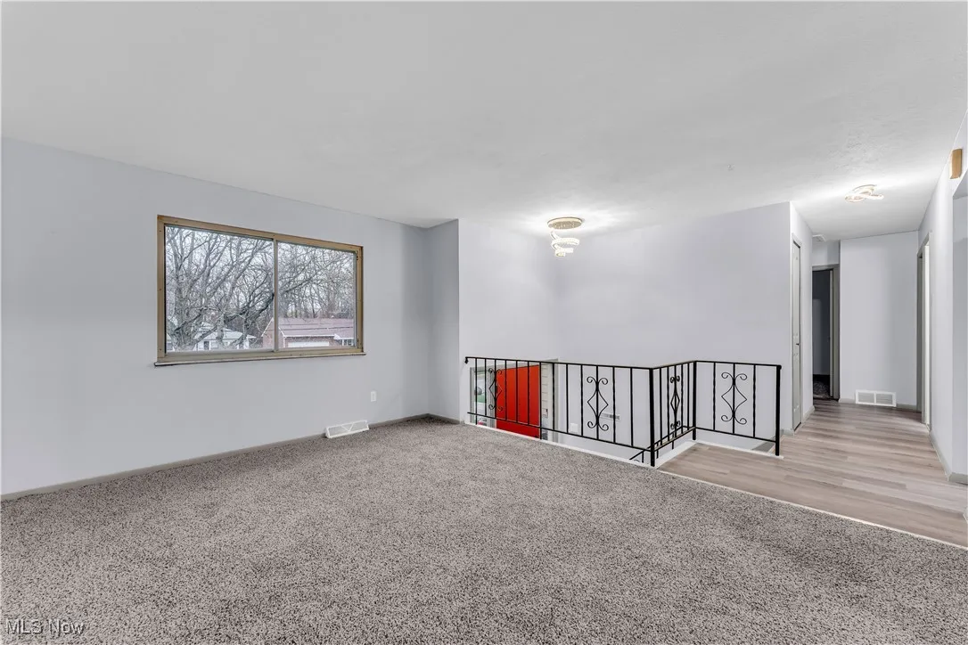 Carpeted empty room with baseboards and visible vents