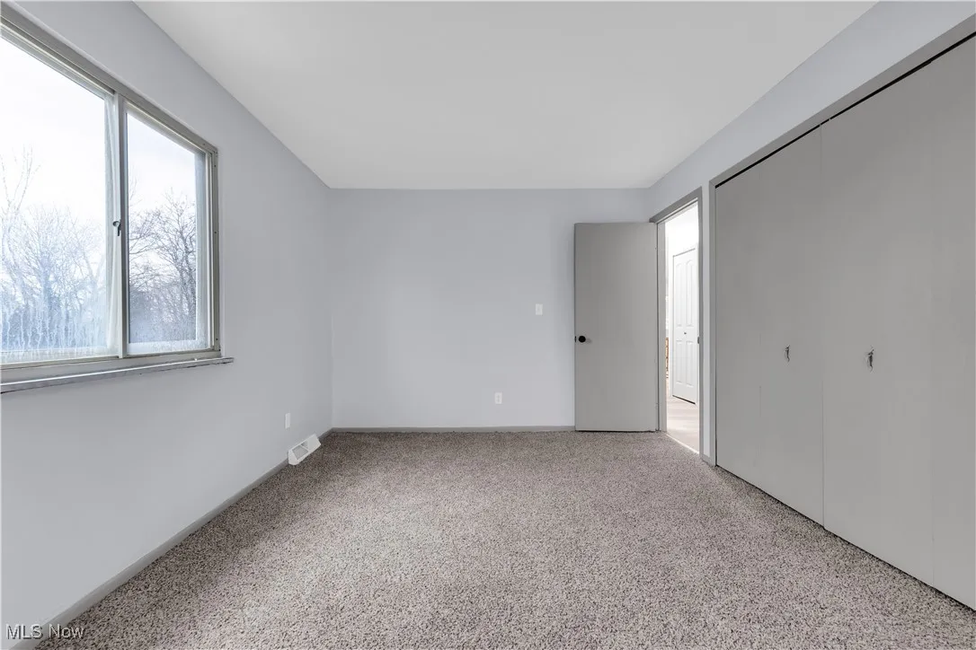 Unfurnished bedroom with visible vents, a closet, and carpet floors