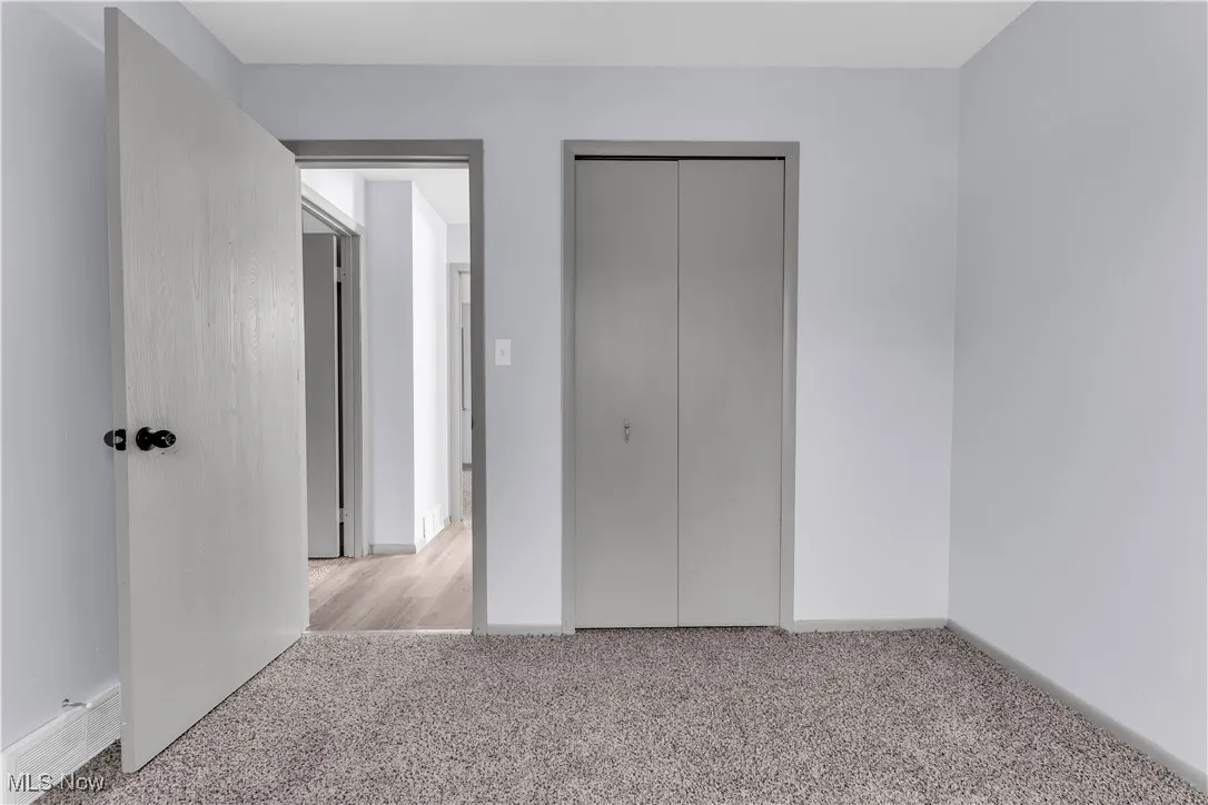 Unfurnished bedroom with a closet, baseboards, and carpet