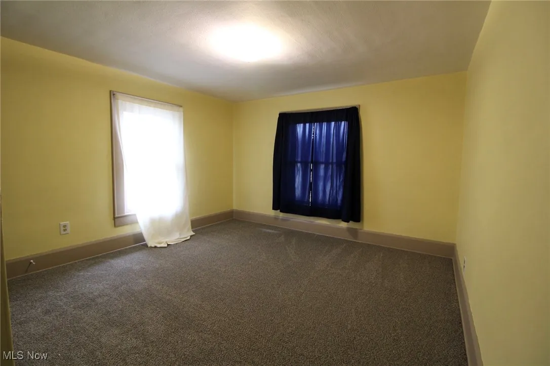 Carpeted empty room with baseboards