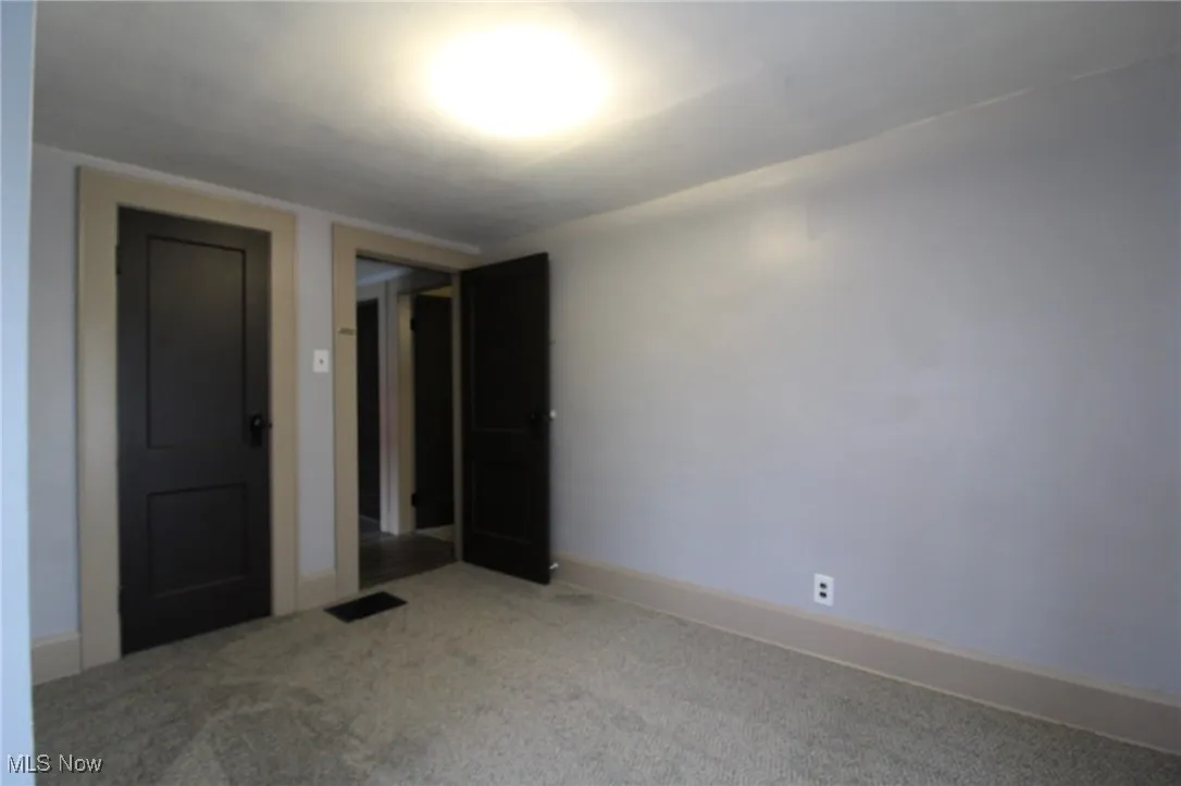 Carpeted spare room with baseboards