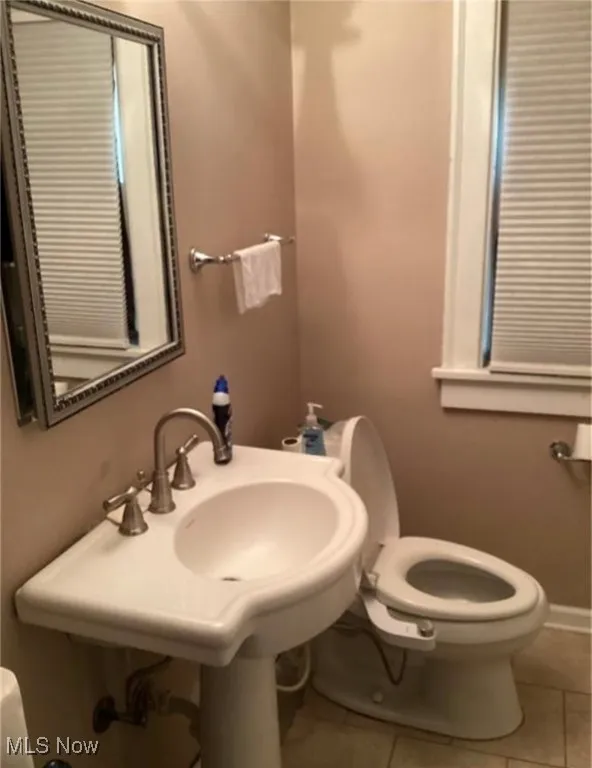 Half bathroom featuring tile patterned flooring and toilet