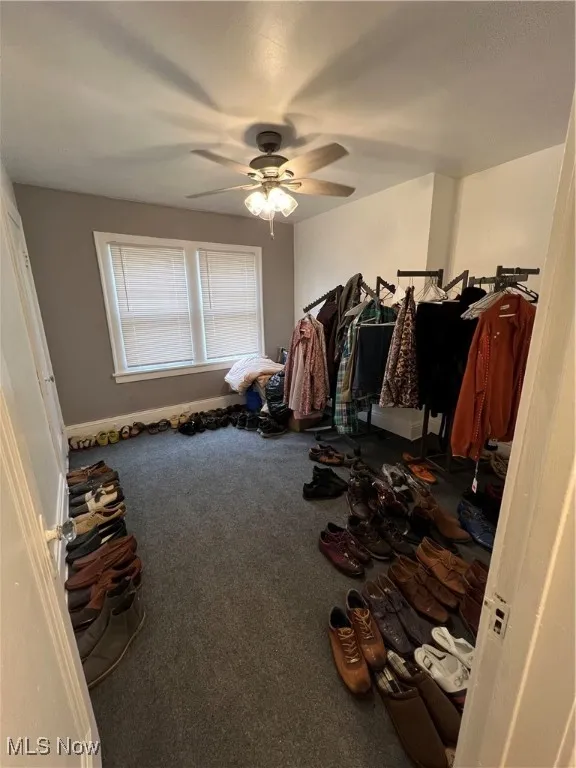 Bedroom with carpet, baseboards, and a ceiling fan