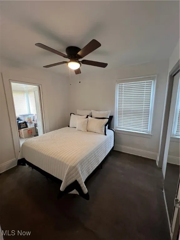 Bedroom featuring dark carpet, baseboards, and ceiling fan