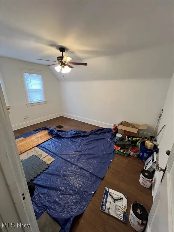 Bedroom with ceiling fan, baseboards, wood finished floors, and lofted ceiling