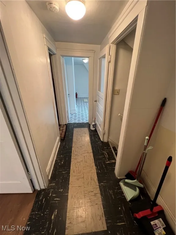 Corridor with baseboards and dark floors