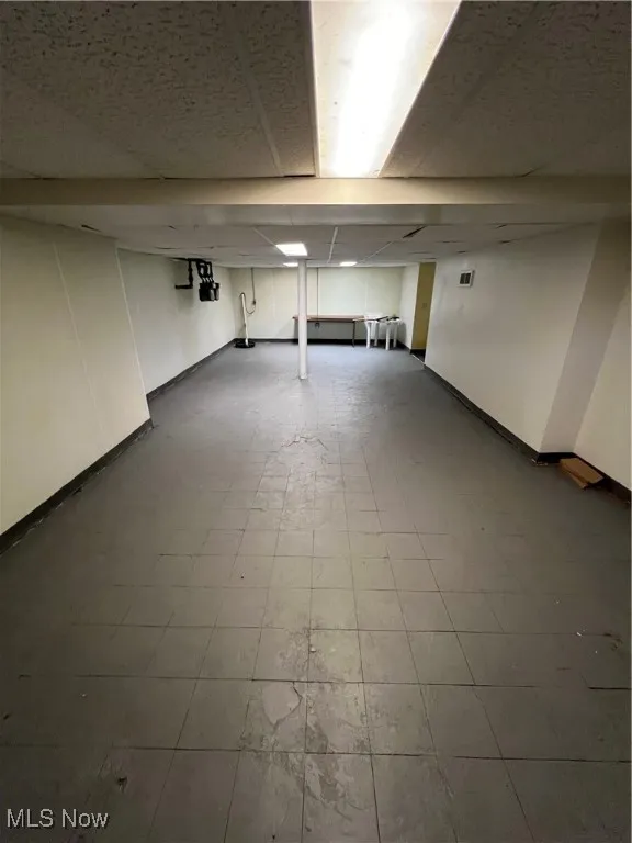 Finished basement with tile patterned floors and baseboards