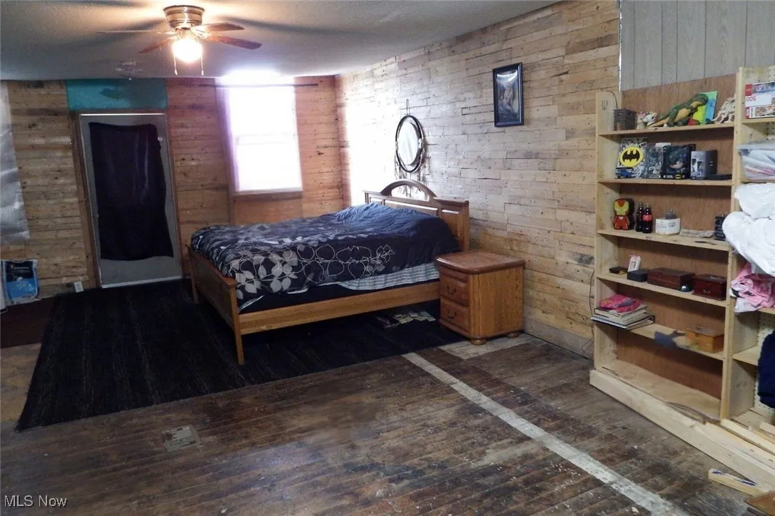 Bedroom featuring wooden walls and hardwood / wood-style floors
