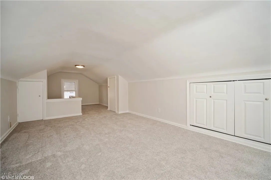 Bonus room with baseboards, carpet, and vaulted ceiling