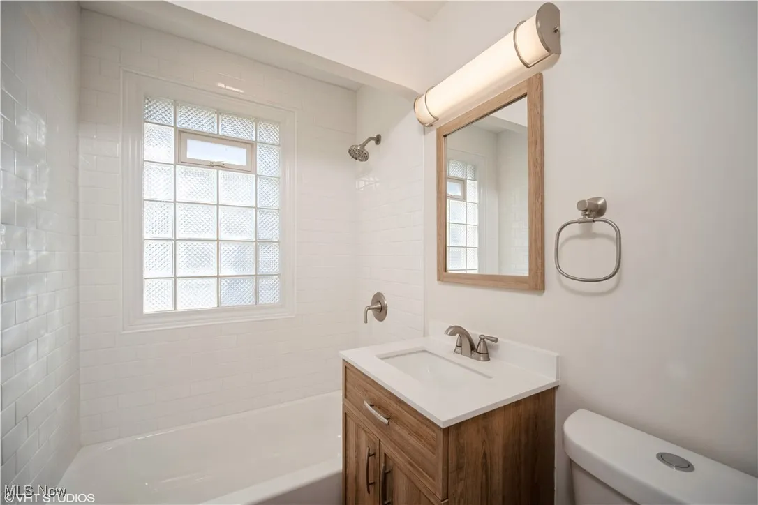 Full bathroom with toilet, bathing tub / shower combination, and vanity