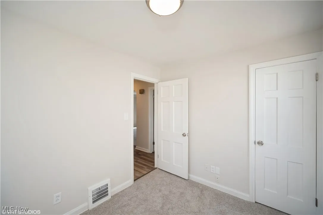 Unfurnished bedroom with baseboards, carpet, and visible vents
