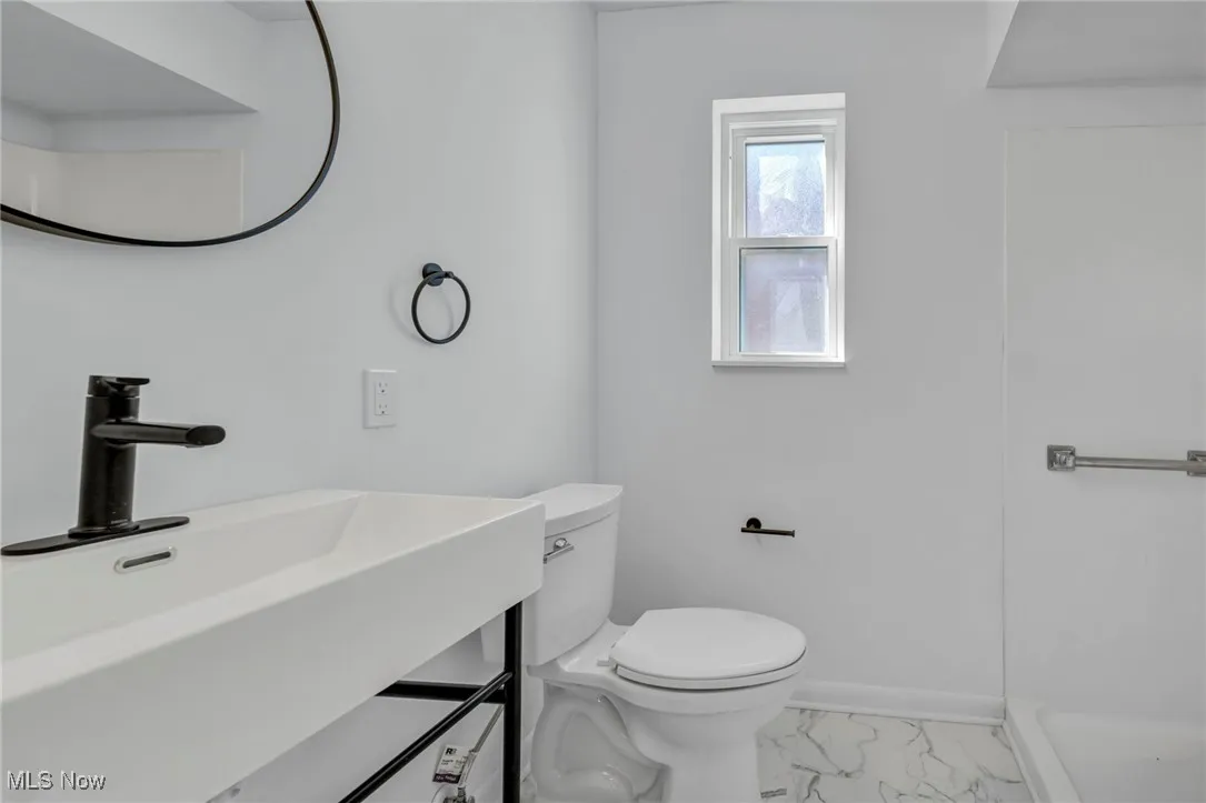 Bathroom with vanity, marble finish floor, baseboards, and toilet
