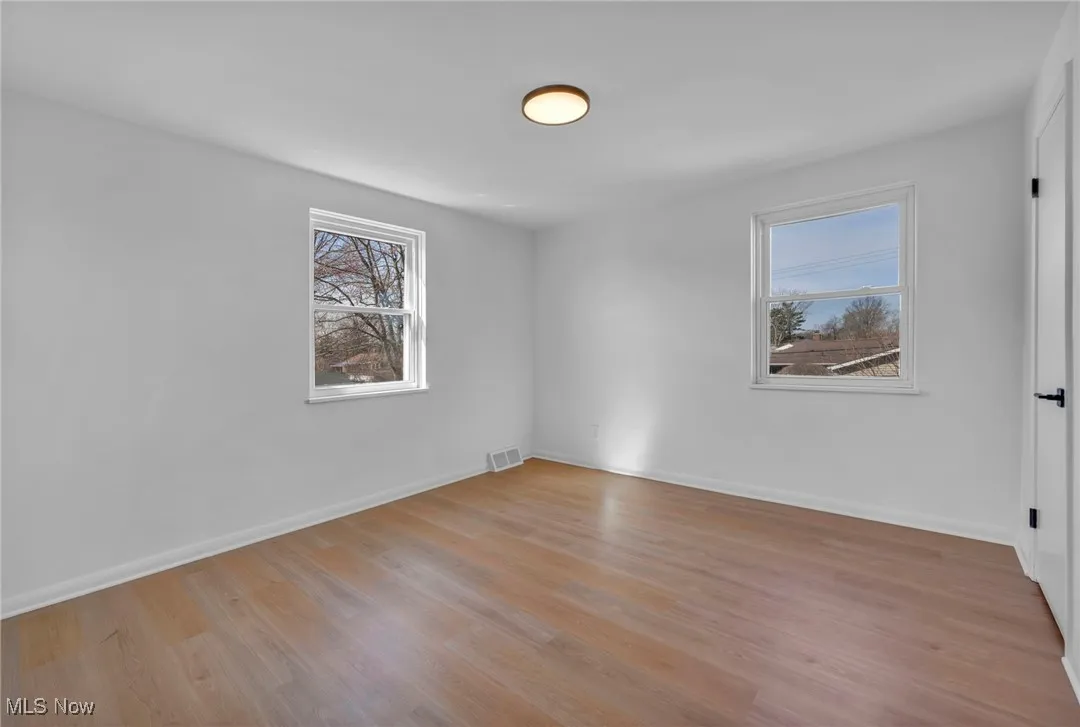 Unfurnished room with light wood-type flooring, baseboards, and visible vents
