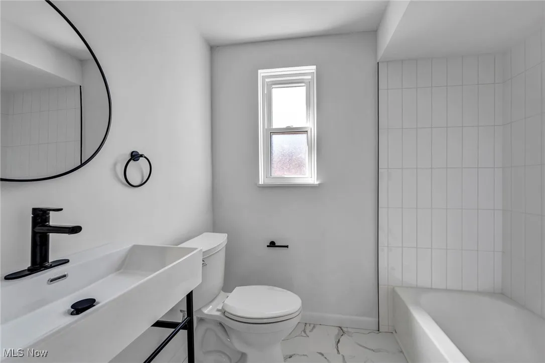 Full bathroom featuring toilet, marble finish floor, baseboards, and vanity