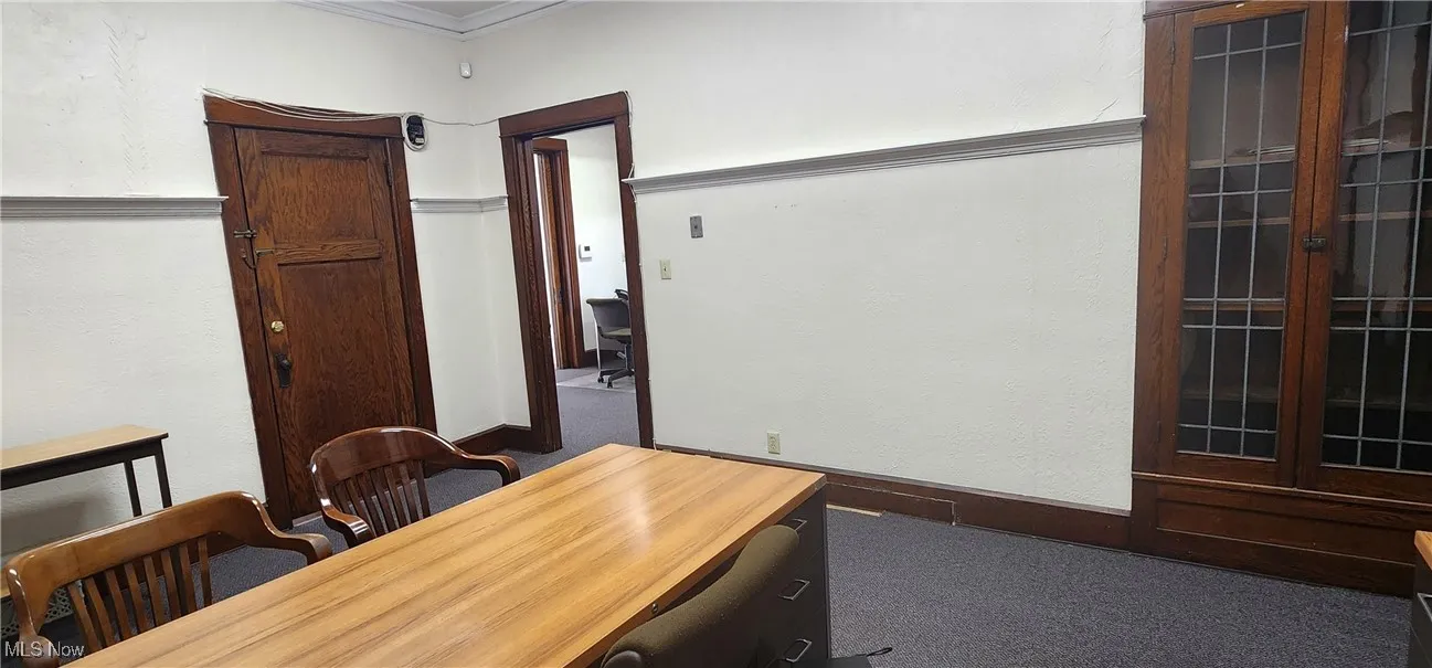 Unfurnished office featuring carpet flooring and ornamental molding