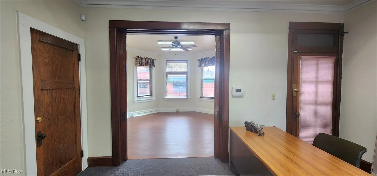 Hall featuring crown molding and dark wood-type flooring