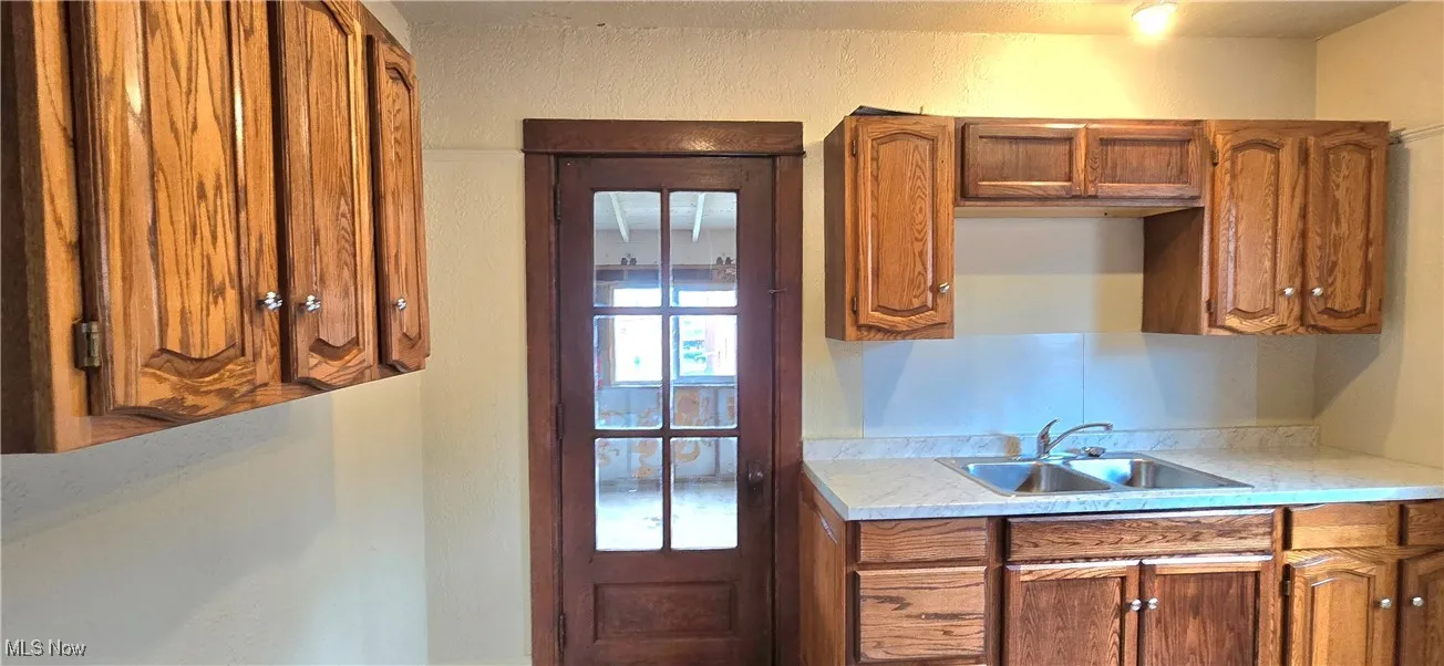 Kitchen featuring brown cabinetry, a sink, and light countertops