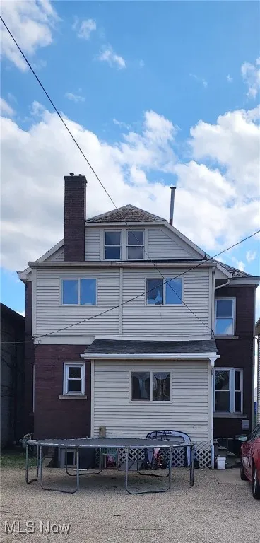 Back of property featuring a trampoline